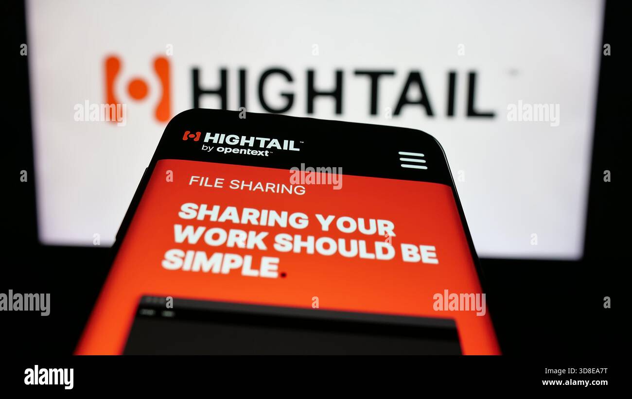 Stoccarda, Germania - 11-19-2025: Telefono cellulare con sito web della società statunitense di servizi di condivisione file Hightail sullo schermo davanti al logo. Foto Stock