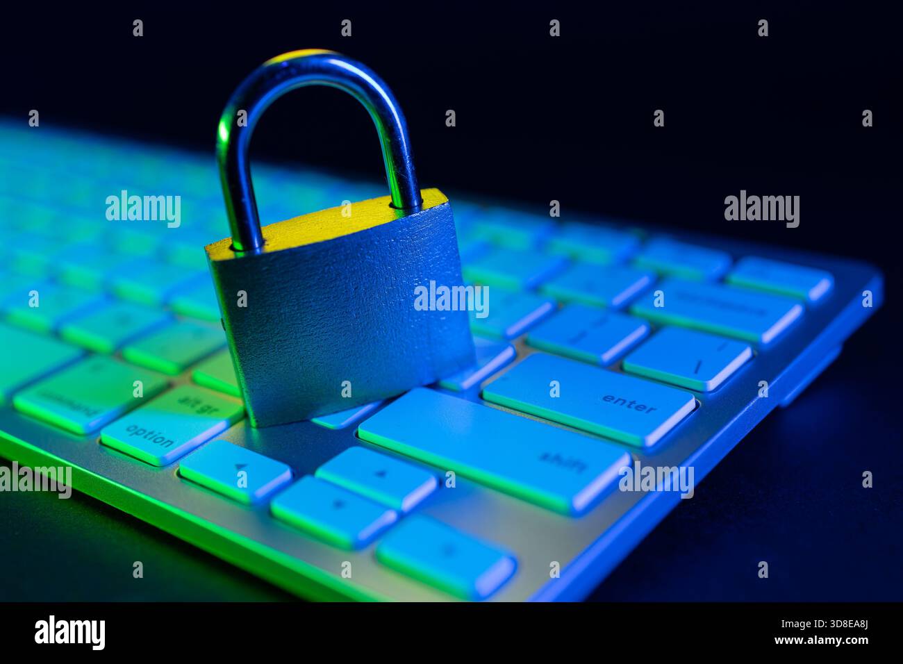 Un lucchetto poggia sulla tastiera di un computer illuminato da luci colorate. Questa scena evidenzia l'importanza della sicurezza Internet in un digitale moderno Foto Stock