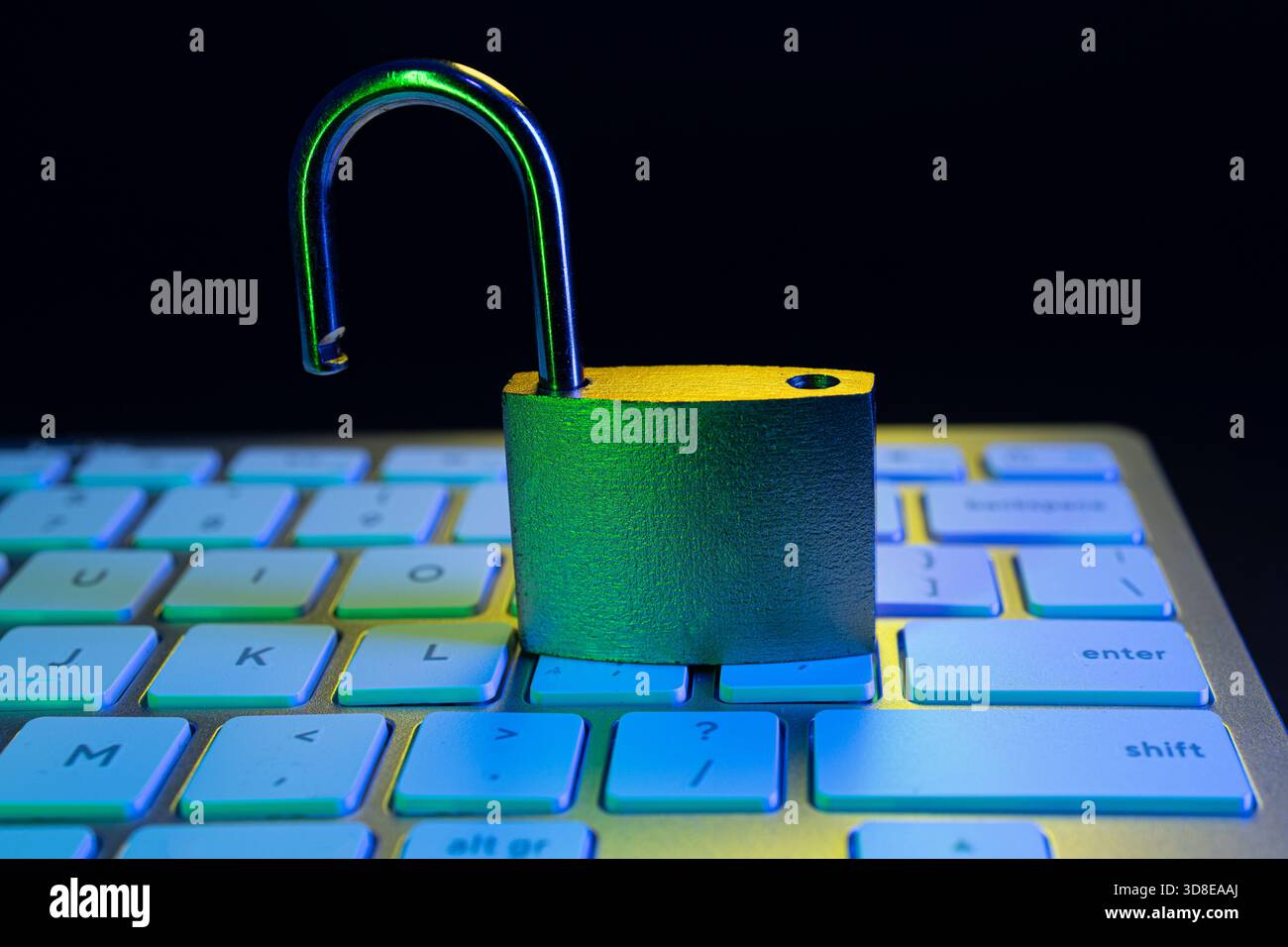 Un lucchetto aperto si trova sulla tastiera di un computer, simboleggiando la vulnerabilità nella sicurezza informatica. La scena ha un bagliore colorato che sottolinea l'importanza di Foto Stock