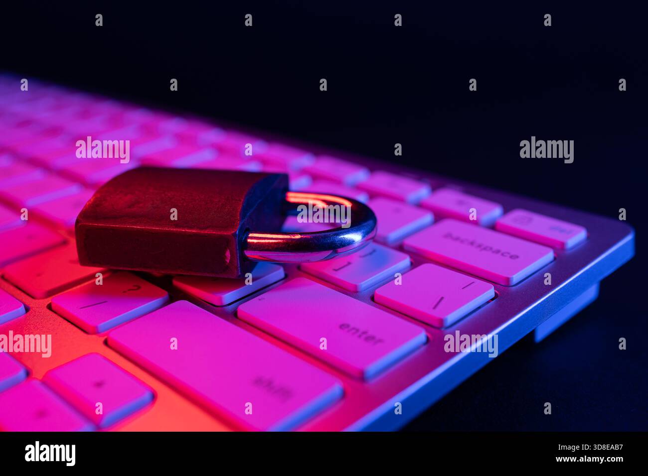 Un lucchetto poggia sulla tastiera di un computer, simboleggiando la sicurezza informatica e la protezione dei dati. La scena evidenzia l'importanza di salvaguardare le informazioni Foto Stock