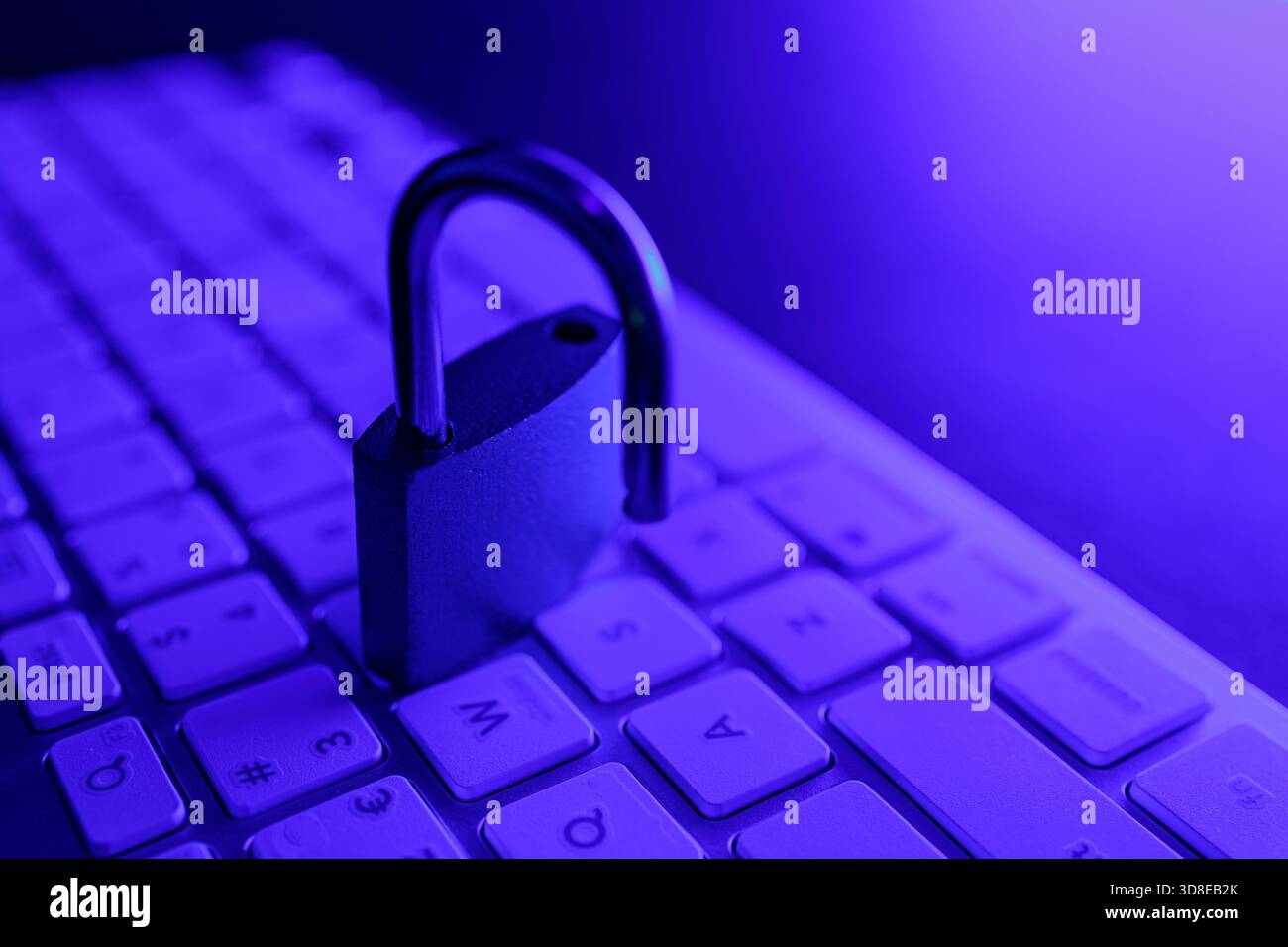 Un blocco di sicurezza si trova sulla tastiera di un computer, indicando l'importanza della sicurezza informatica nella protezione delle informazioni personali. La scena è illuminata Foto Stock