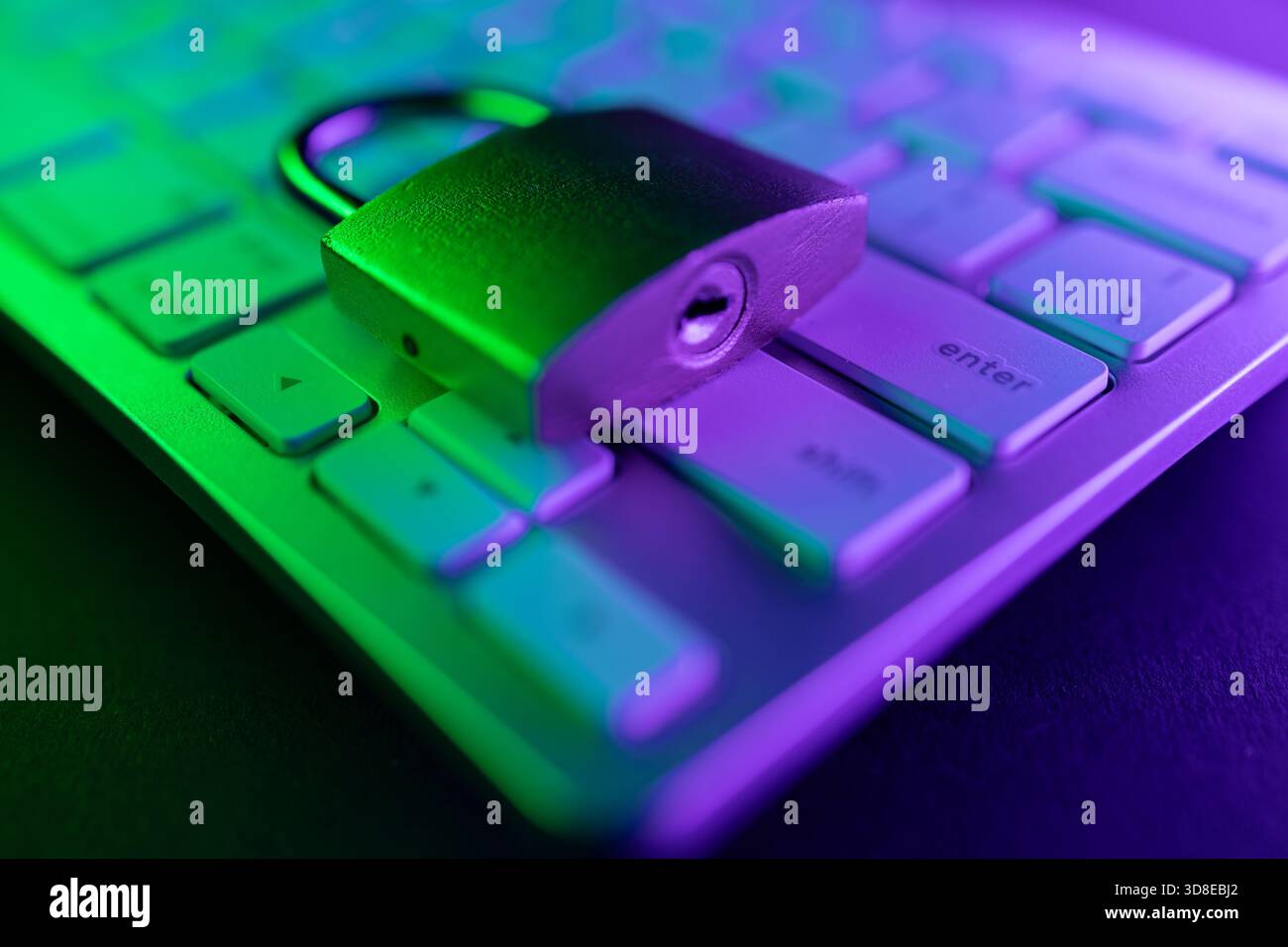 Un lucchetto metallico poggia sulla tastiera di un computer, simboleggiando la sicurezza Internet. La luce colorata aggiunge un tocco moderno al concetto di protezione del perso Foto Stock