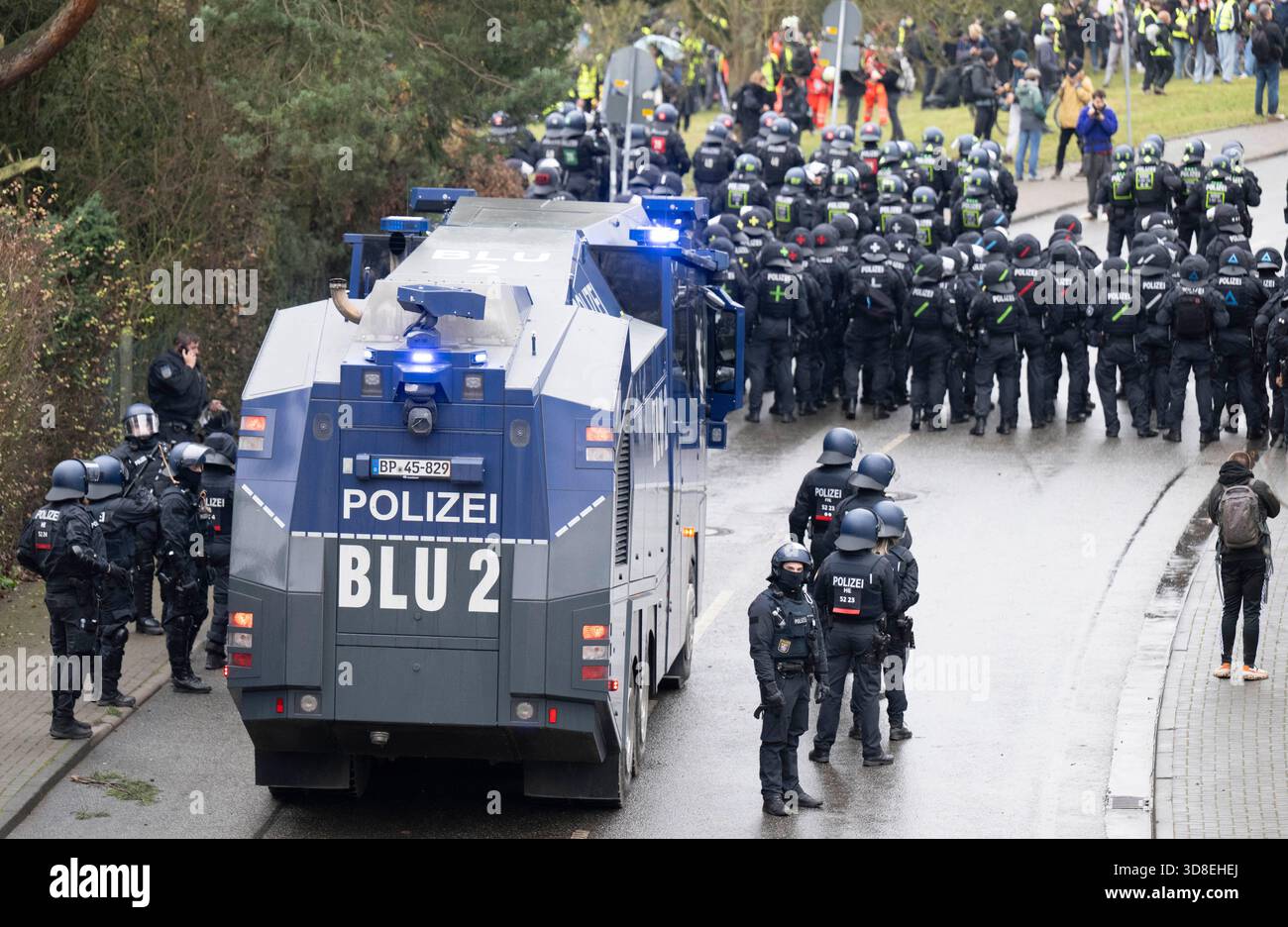29 novembre 2025, Assia, Gießen: Gli agenti di polizia e un cannone d'acqua bloccano l'accesso per i manifestanti vicino alla sala riunioni. Diverse migliaia di manifestanti hanno protestato contro la fondazione di una nuova organizzazione giovanile AfD sabato. Il suo predecessore, Junge alternative, che era stato classificato come estremista di destra, si era dissolto. Foto: Boris Roessler/dpa Foto Stock