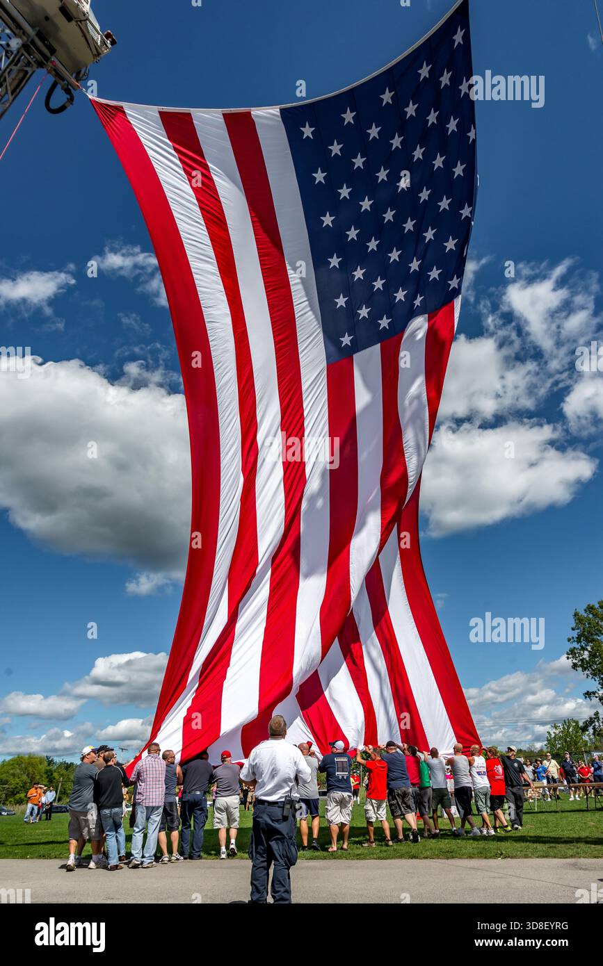 9-11 ricordo come due compagnie di vigili del fuoco vicine alzano la bandiera americana. Foto Stock