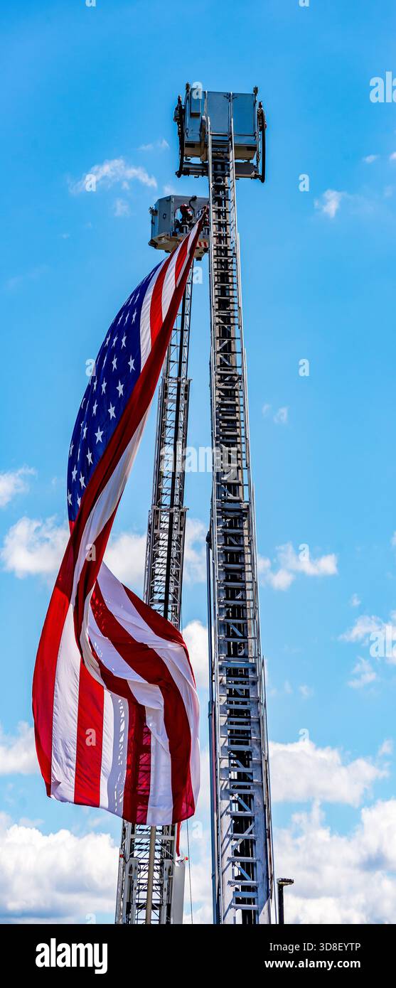 9-11 ricordo come due compagnie di vigili del fuoco vicine alzano la bandiera americana. Foto Stock