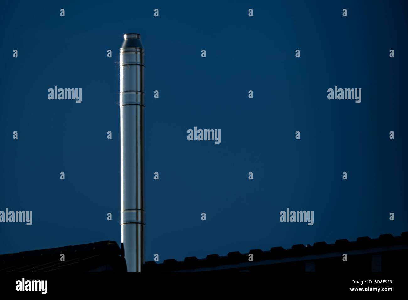 22.11.2025, Modernisierungsmassnahme, Waermeversorgung Edelstahlkamin reflektiert in der Morgensonne Rheinbach NRW Deutschland *** 22 11 2025, misura di ammodernamento, camino in acciaio inossidabile per la fornitura di calore riflesso nel sole mattutino Rheinbach NRW Germania Copyright: XWolfingerx Foto Stock