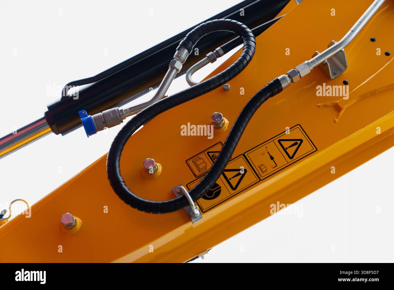 Componenti dell'impianto idraulico con coperture protettive dei tubi flessibili, simboli di avvertenza e raccordi metallici montati su un braccio di costruzione lucida utilizzato nel dut pesante Foto Stock