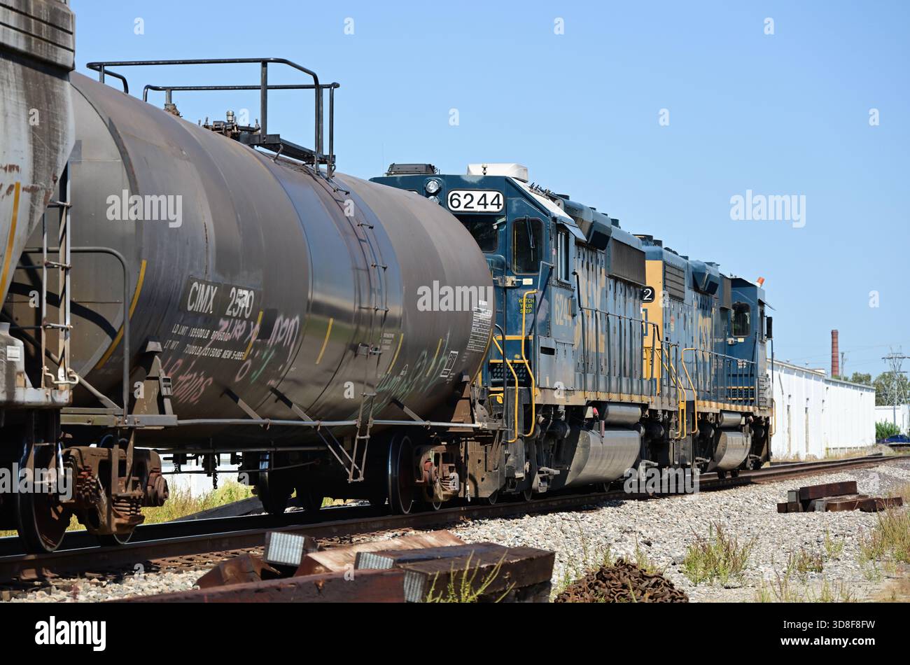 Hoopeston, Illinois, Stati Uniti. Un paio di locomotive guidano un treno merci locale CSX Transportation diretto a nord che attraversa una piccola comunità. Foto Stock