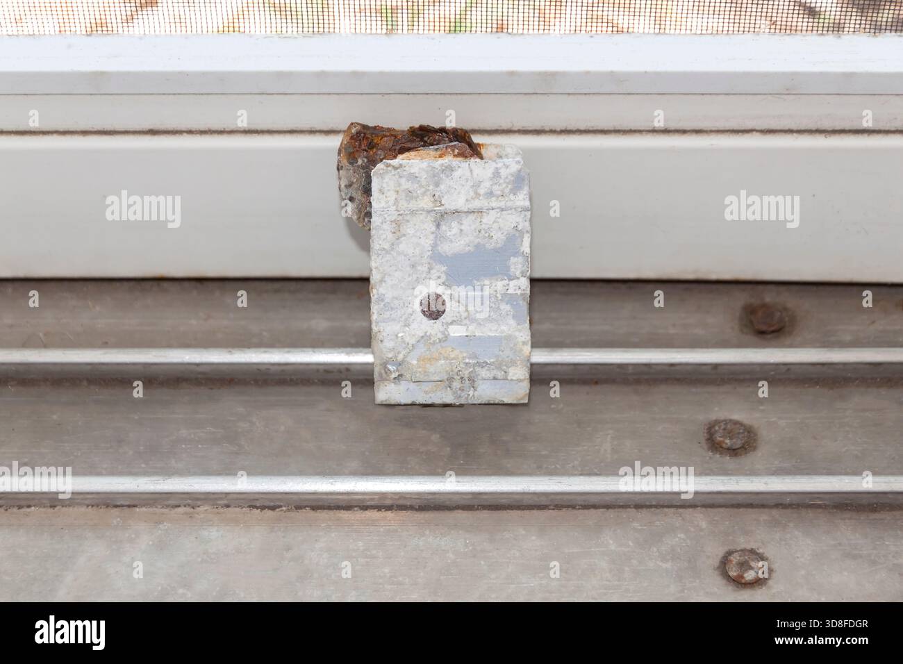 Rullo della porta scorrevole corroso da sostituire su un patio domestico. Foto Stock