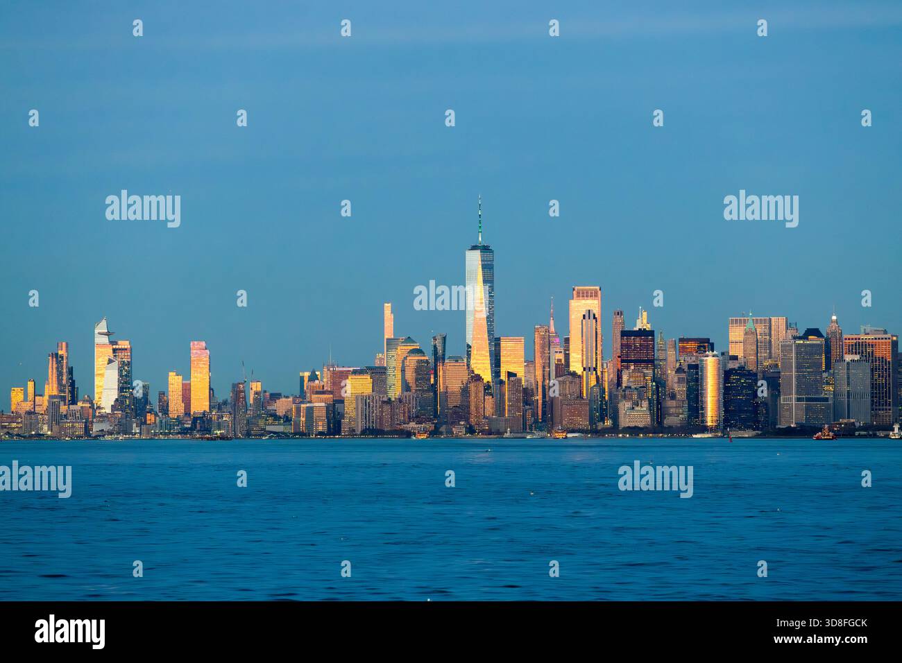Vista di Manhattan a New York dall'acqua dopo il tramonto. Foto Stock