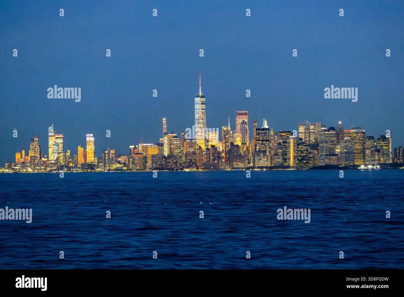 Vista di Manhattan a New York dall'acqua dopo il tramonto. Foto Stock