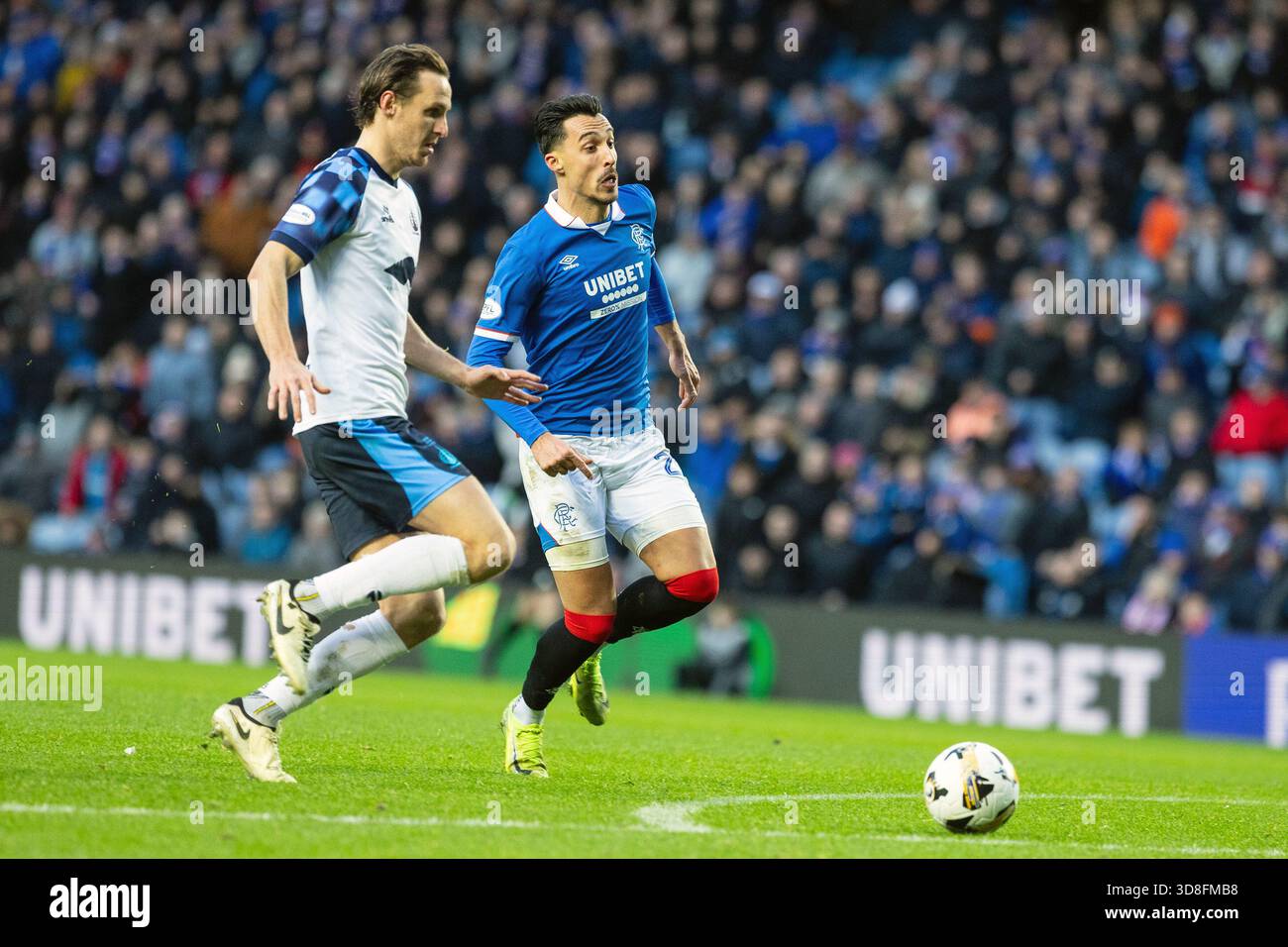 Glasgow, Regno Unito. 30 novembre 2025. I Rangers FC hanno giocato contro il Falkirk allo stadio Ibrox di Glasgow, in Scozia, in una partita della William Hill Premiership. Il punteggio finale è stato Rangers 0-0 Falkirk. Bojan Miovski (R28) e Liam Henderson (F5) corrono per il pallone vicino ai gol di Falkirk. Crediti: Findlay/Alamy Live News Foto Stock
