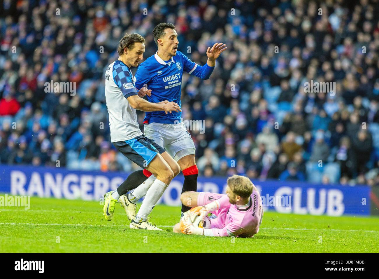 Glasgow, Regno Unito. 30 novembre 2025. I Rangers FC hanno giocato contro il Falkirk allo stadio Ibrox di Glasgow, in Scozia, in una partita della William Hill Premiership. Il punteggio finale è stato Rangers 0-0 Falkirk. Scott Bain, portiere del Falkirk, ferma la palla vicino ai suoi gol, mentre Bojan Miovski (R28) e Liam Henderson (F5) gli saltano sopra. Crediti: Findlay/Alamy Live News Foto Stock
