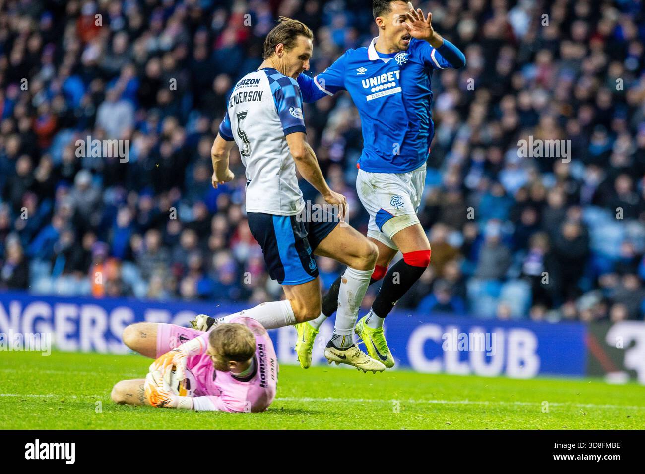 Glasgow, Regno Unito. 30 novembre 2025. I Rangers FC hanno giocato contro il Falkirk allo stadio Ibrox di Glasgow, in Scozia, in una partita della William Hill Premiership. Il punteggio finale è stato Rangers 0-0 Falkirk. Scott Bain, portiere del Falkirk, ferma la palla vicino ai suoi gol, mentre Bojan Miovski (R28) e Liam Henderson (F5) gli saltano sopra. Crediti: Findlay/Alamy Live News Foto Stock