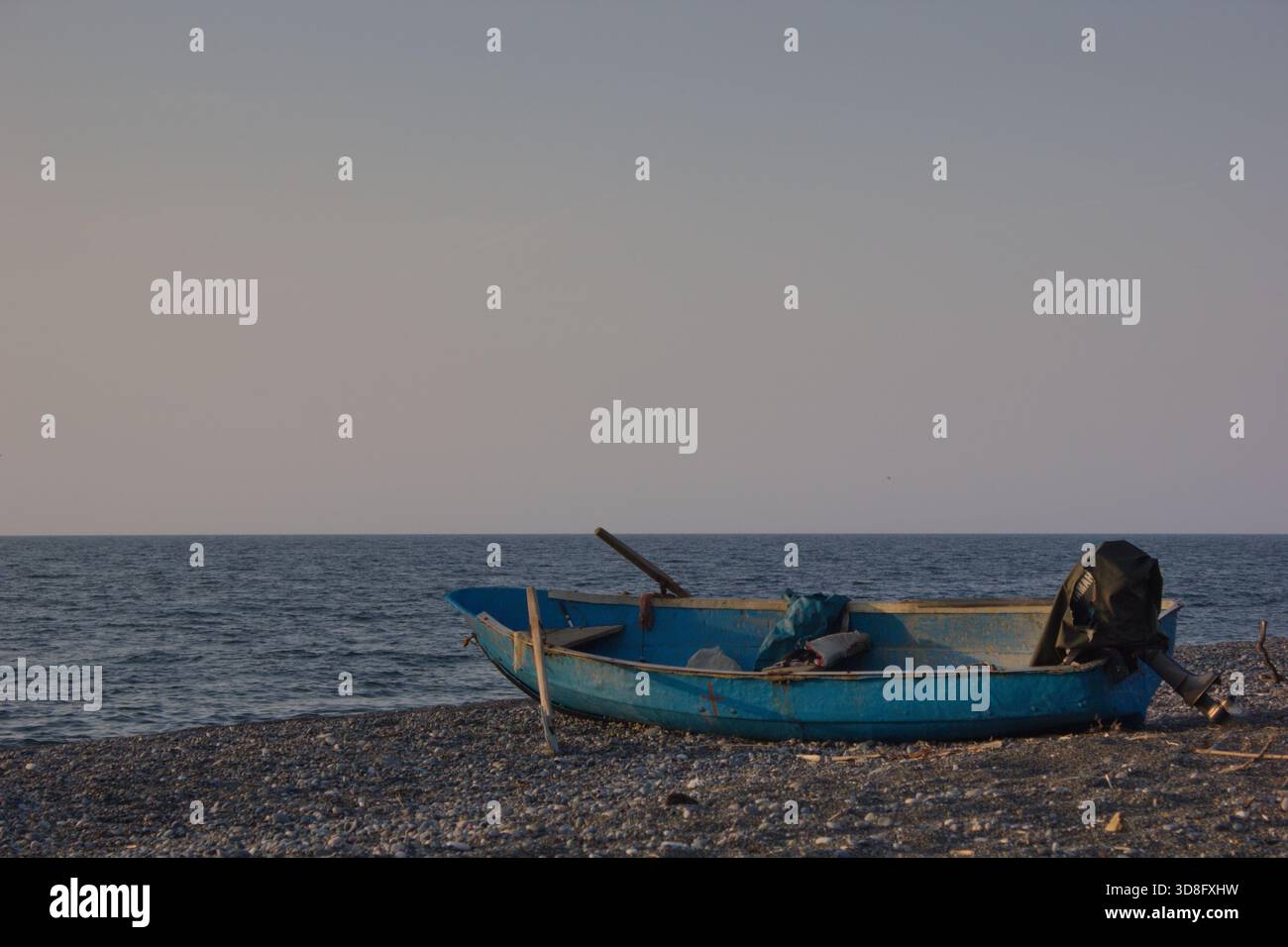 piccola barca da pesca che galleggia sul mare turchese calmo sotto il cielo azzurro, copia spazio Foto Stock