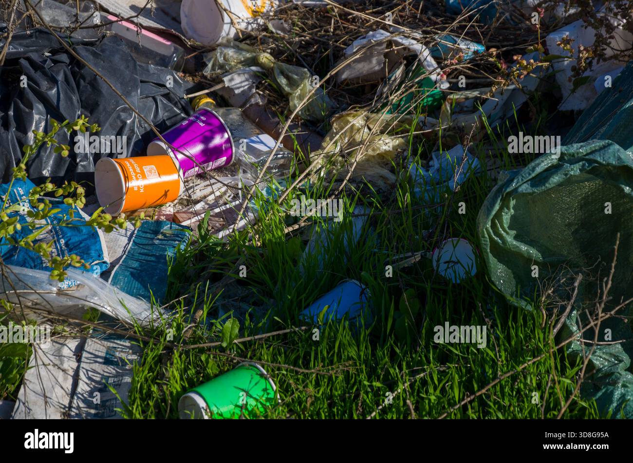 Un mucchio di rifiuti in plastica e usa e getta di prati verdi Foto Stock