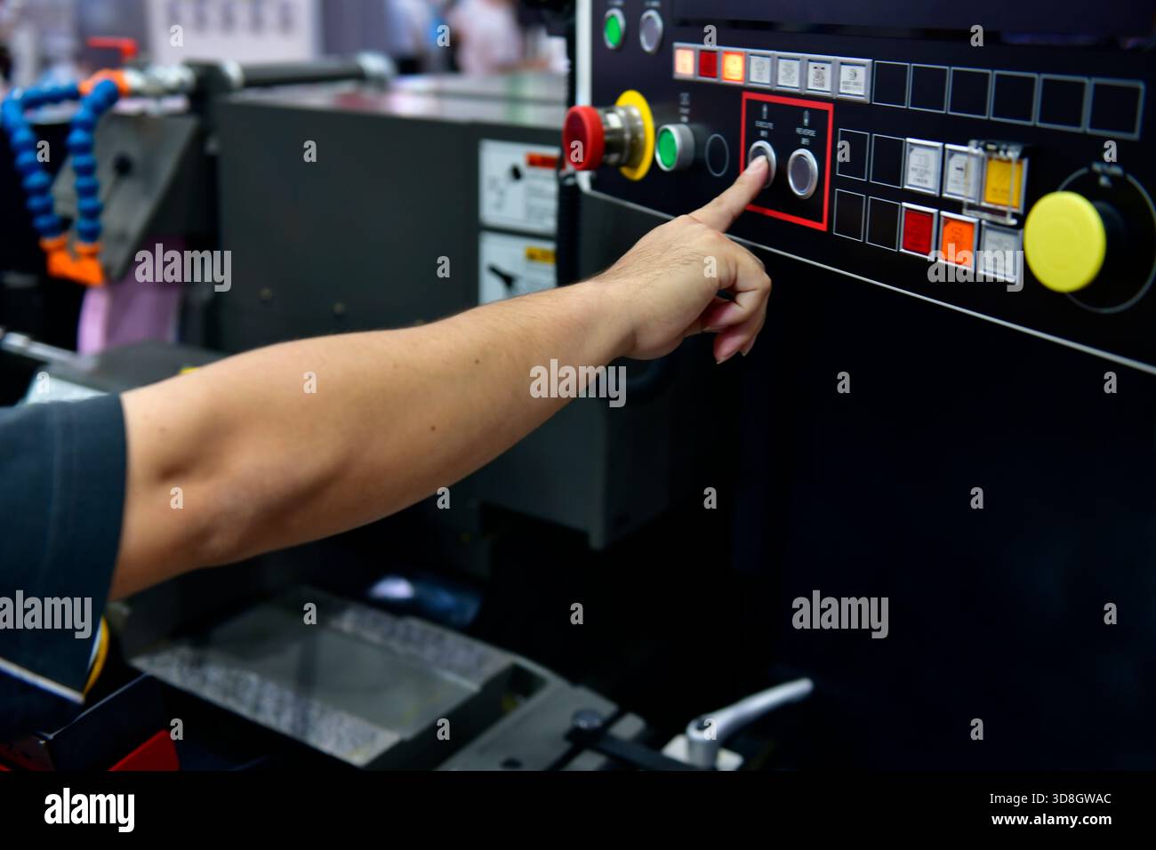 La mano dell'operatore della macchina accende il pannello di controllo della macchina industriale. pulsante tecnico sul pannello di controllo Foto Stock