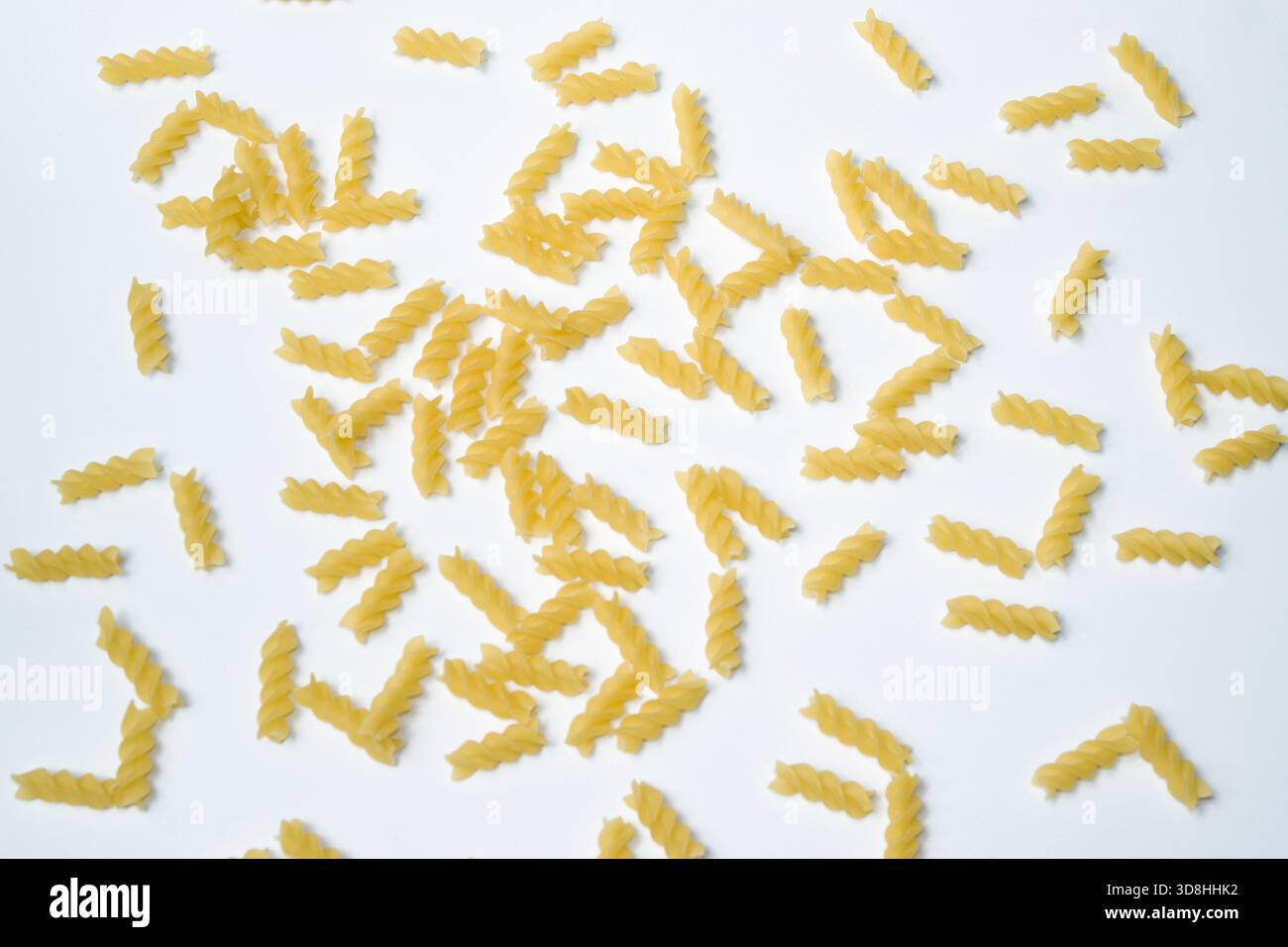 Pasta secca Fusilli sparsi isolata dall'alto bianco verso il basso Foto Stock
