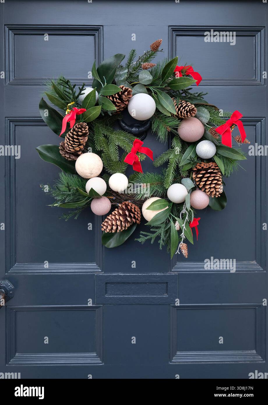 corona di natale sulla porta grigio scuro, burnham market, norfolk, inghilterra Foto Stock