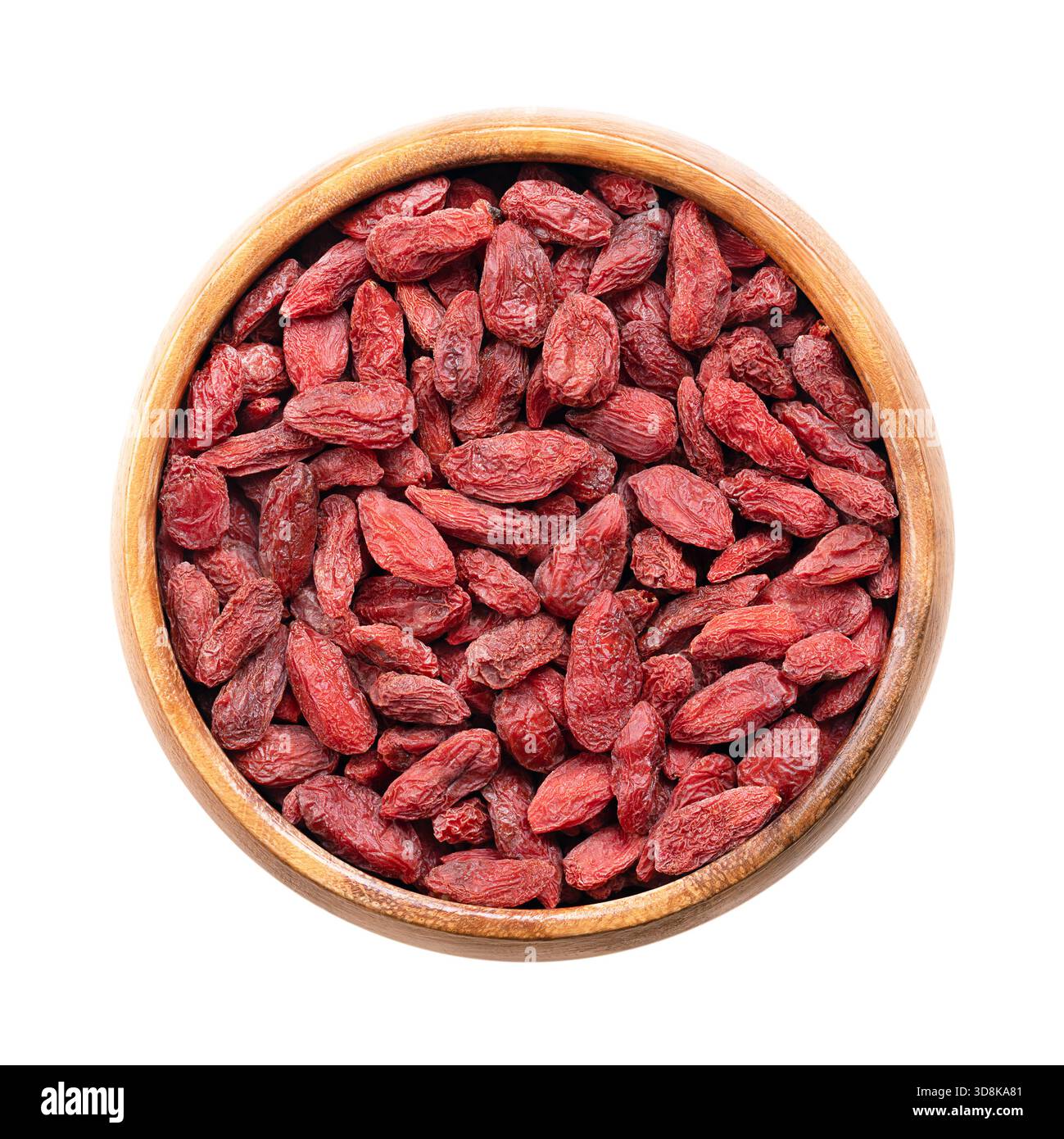 Bacche di goji essiccate, in una ciotola di legno. Conosciuto anche come wolfberry cinese, medlar rosso e vitigno matrimoniale. Frutta dolce rossa-arancione brillante. Foto Stock