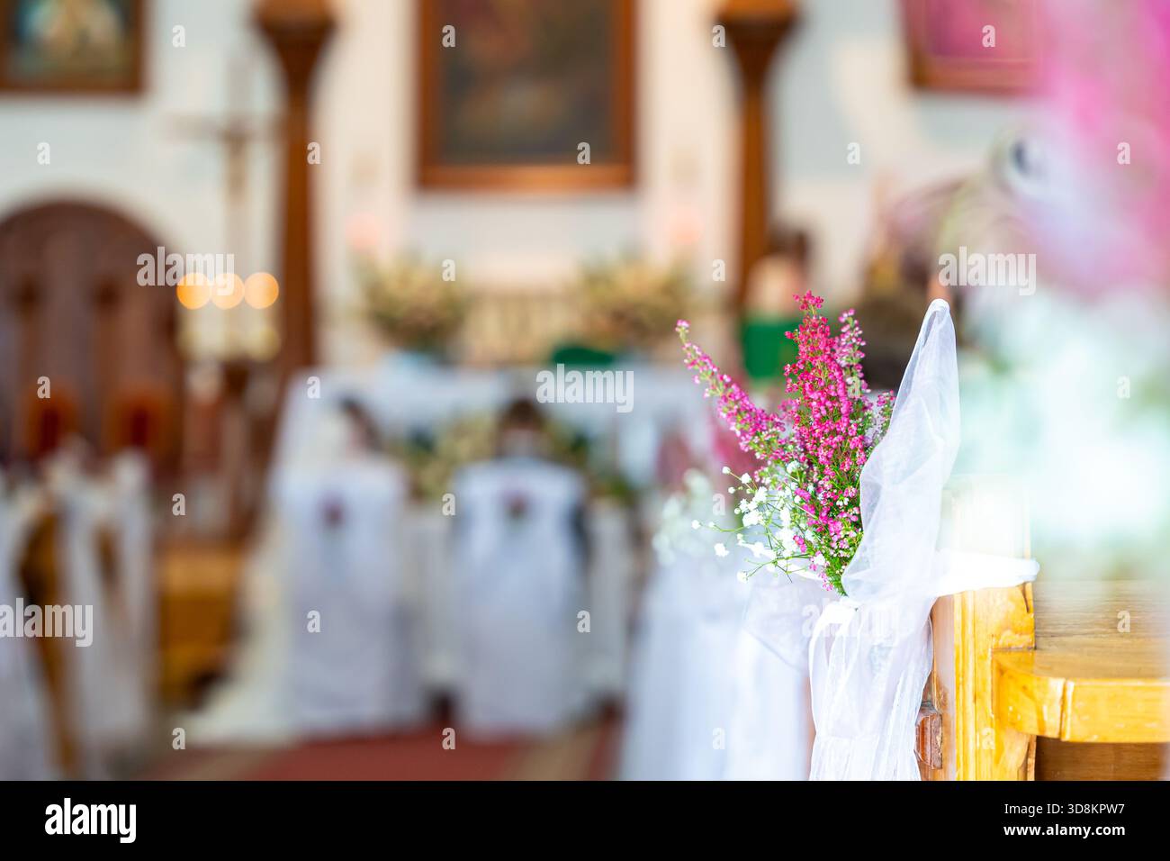 Navata della chiesa nuziale con fiori rosa e soffice illuminazione bokeh per creare un'atmosfera romantica da cerimonia Foto Stock