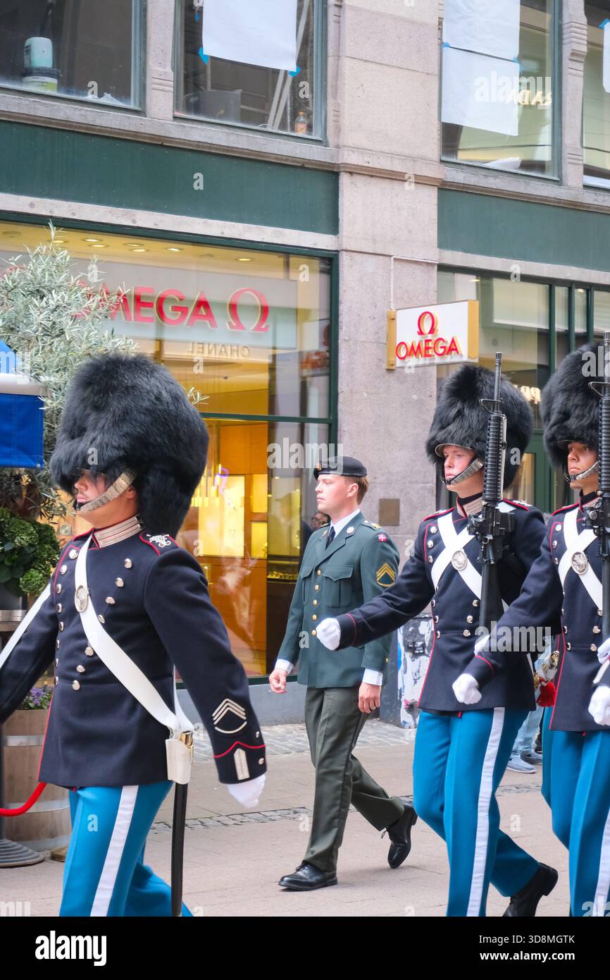 Guardie reali in caschi in pelle d'orso che eseguono una marcia cerimoniale a Copenaghen, Danimarca Foto Stock