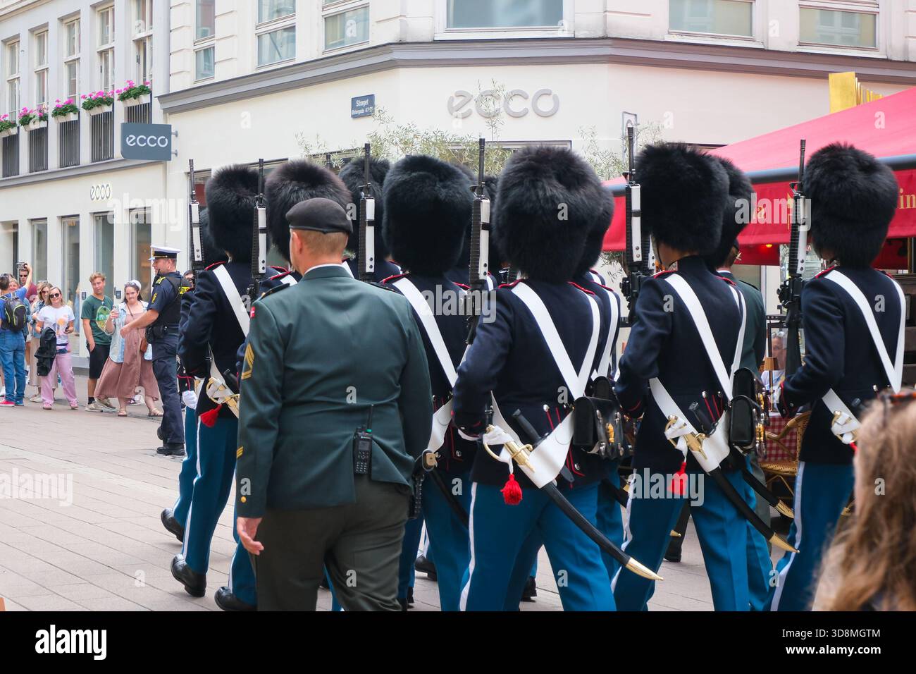 Guardie reali danesi in uniforme che marciano con caschi in pelle d'orso attraverso Copenhagen Street, Danimarca Foto Stock