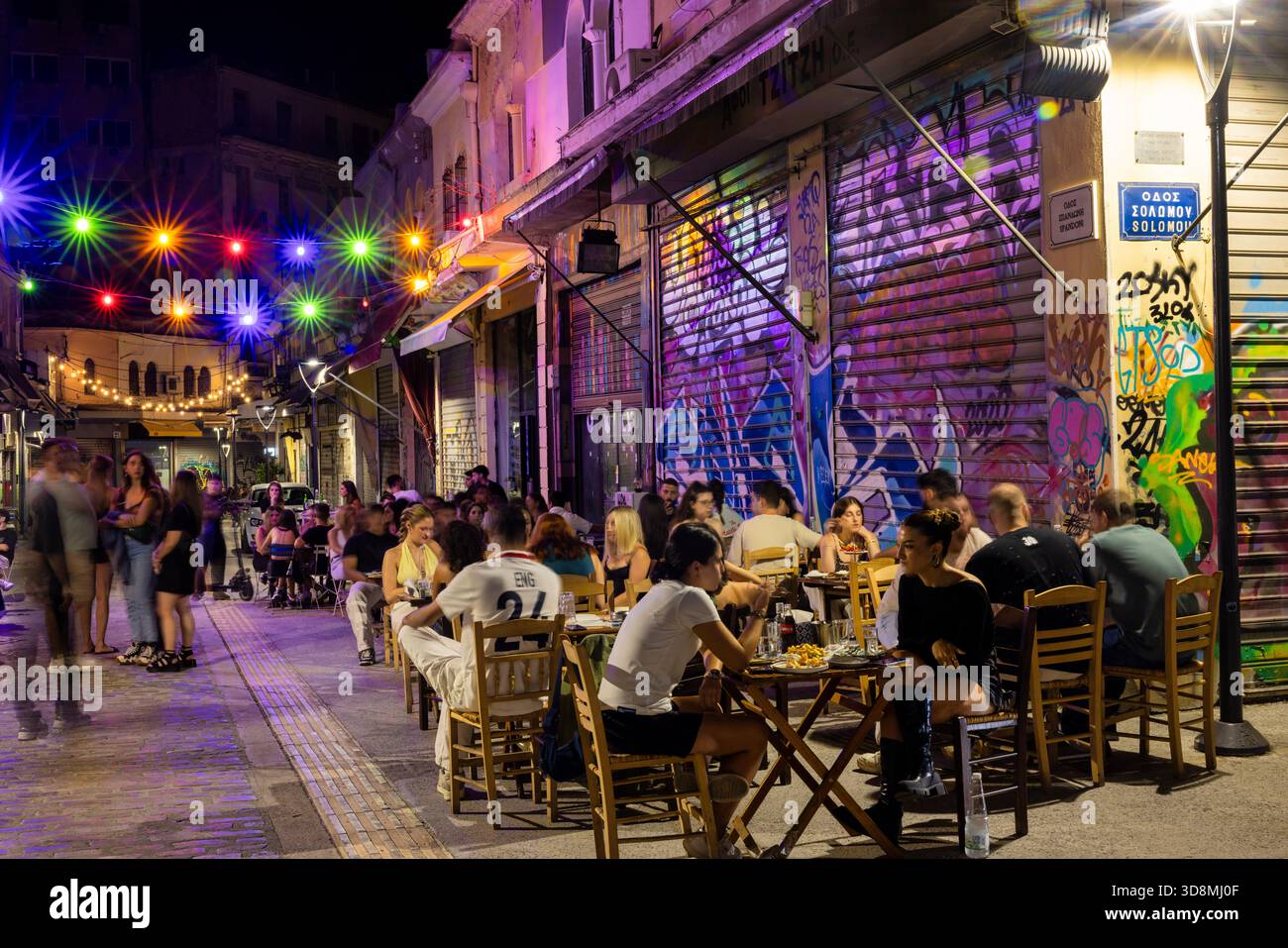 Salonicco, Grecia, 17 settembre 2025. Il mercato di Kapani si trasforma in un vivace centro di ristorazione con tavoli, cibo e persone sotto le luci festose. Foto Stock