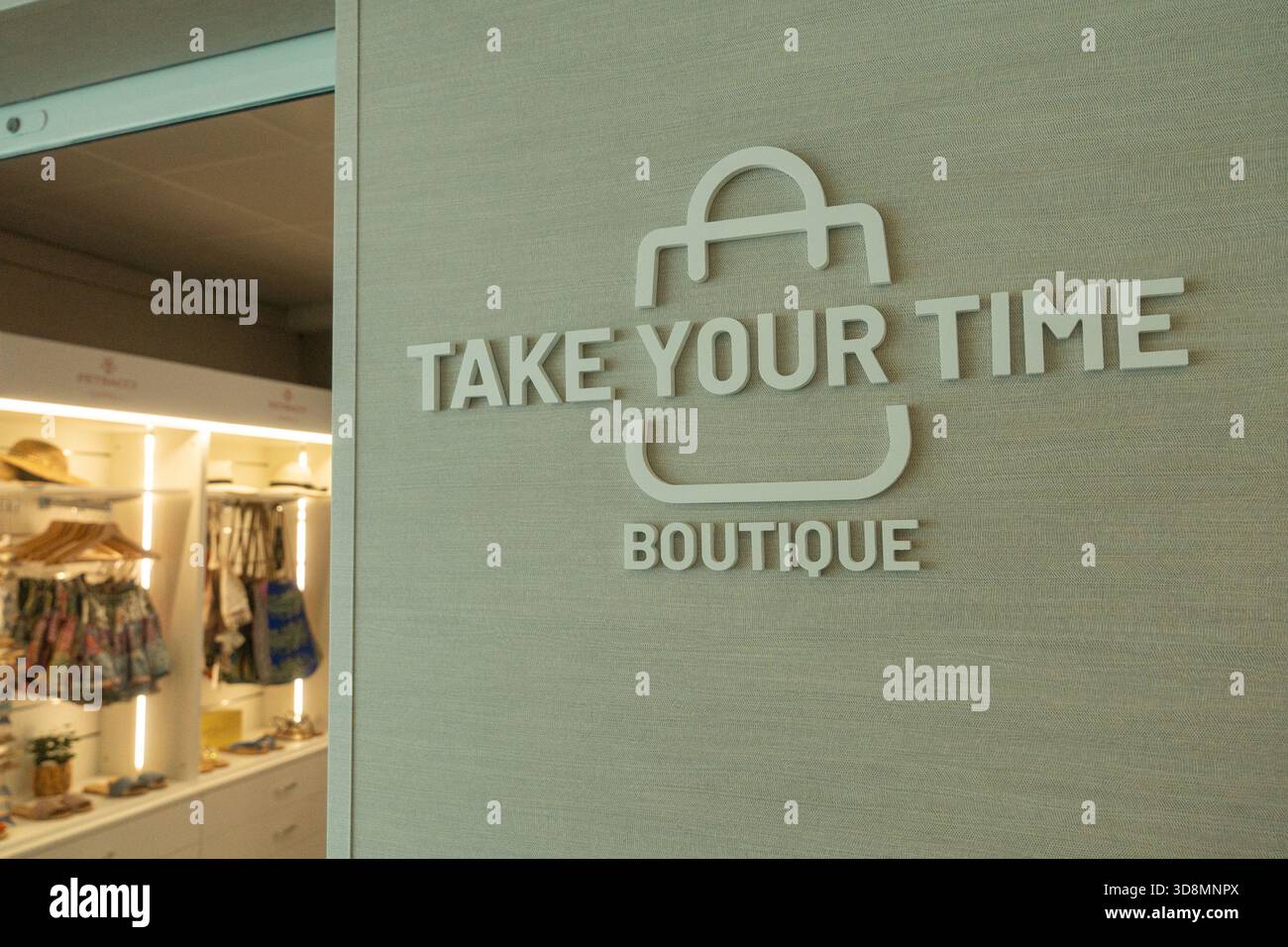 Primo piano di un cartello di un negozio di boutique che legge prenditi il tuo tempo Boutique Soft Lighting mette in risalto il design pulito e moderno e l'elegante atmosfera dello shopping Foto Stock
