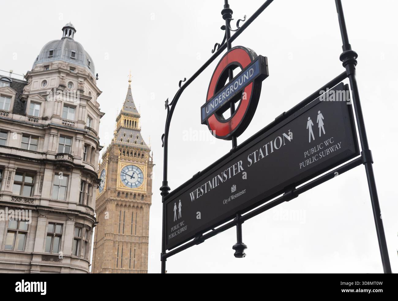 L'insegna della stazione di Westminster incornicia il Big Ben e gli edifici storici in un giorno coperto. Londra Regno Unito Foto Stock