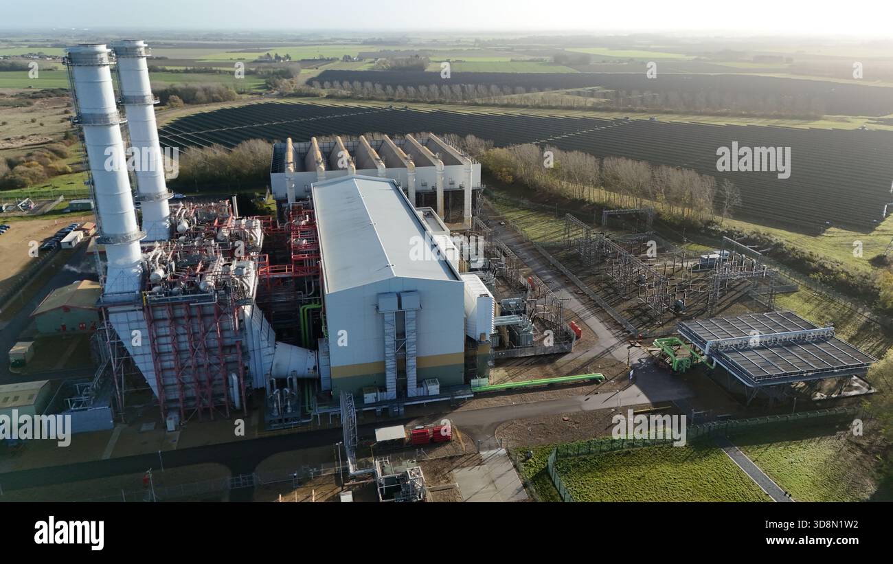 Vista dall'alto della centrale elettrica sullo sfondo dei pannelli solari, la luce del mattino che proietta lunghe ombre nel paesaggio, Foto Stock