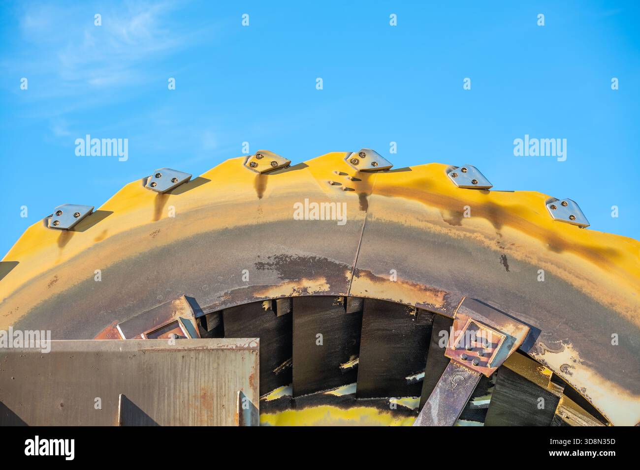 Ruota a secchio industriale utilizzata nell'estrazione della ghiaia Rheinkies, fotografata con un sorprendente contrasto giallo-blu nell'alto Reno Graben, Pfalz, Germania. Foto Stock