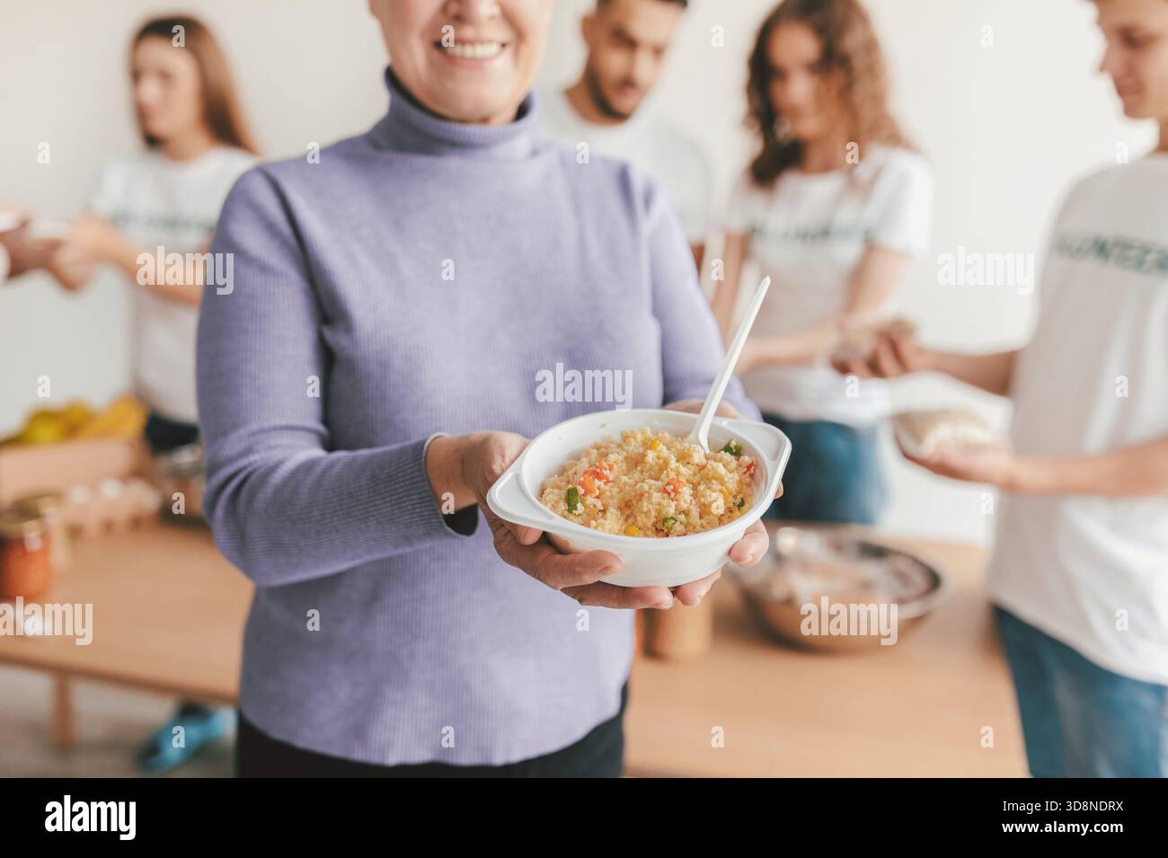 Gruppo di amici che si divertono a cucinare in un luminoso spazio cucina Foto Stock