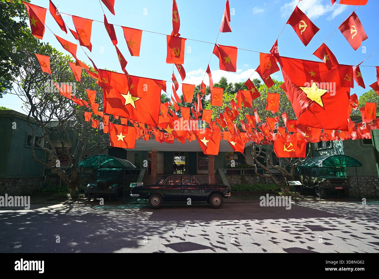 Le bandiere del Vietnam del Partito Nazionale e Comunista sventolano fuori dalla Casa D67, ex quartier generale della Commissione militare centrale e del Politburo di Hanoi Foto Stock