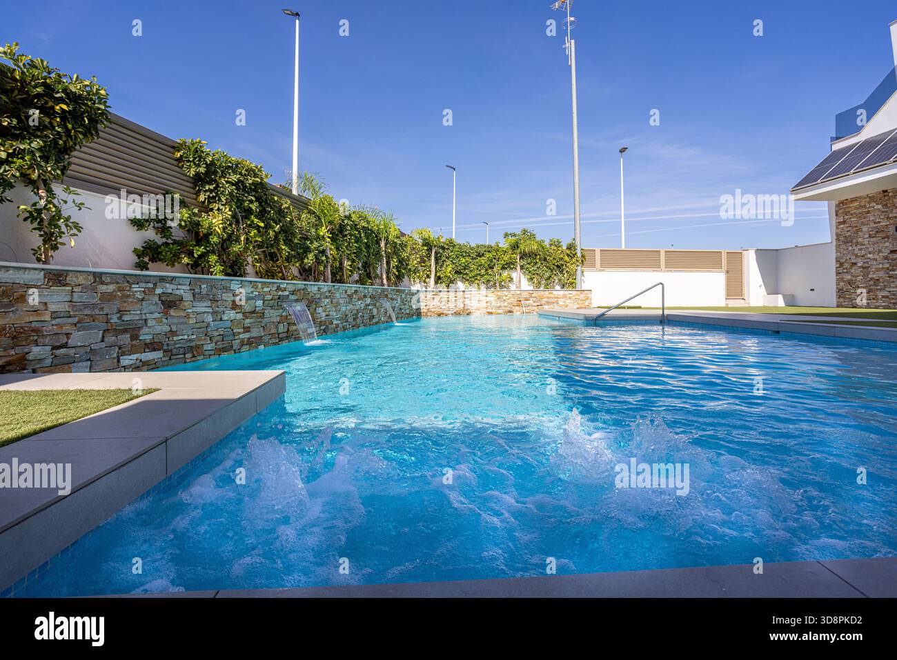 Getti d'acqua gorgoglianti e cascate in una moderna piscina all'aperto Foto Stock