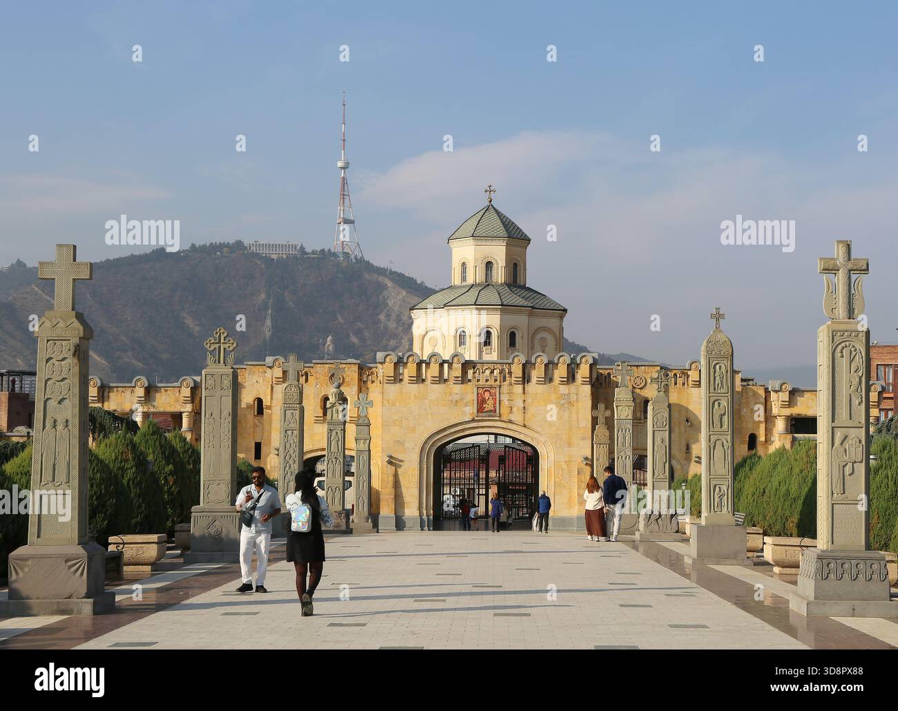 Tbilisi, Georgia-13 novembre 2025: Persone non identificate che camminano a Sameba, nota anche come la Cattedrale della Santissima Trinità con molte croci e l'antenna TV alta Foto Stock