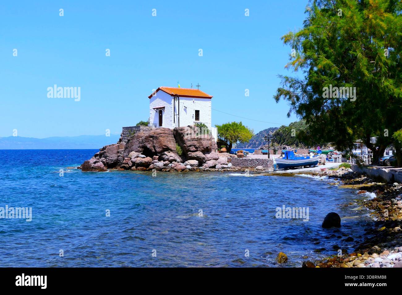 Vista panoramica della chiesa greco-ortodossa di Panagia Gorgona, dipinta di bianco, nel villaggio di Skala Sikamineas sull'isola di Lesbo, in Grecia Foto Stock
