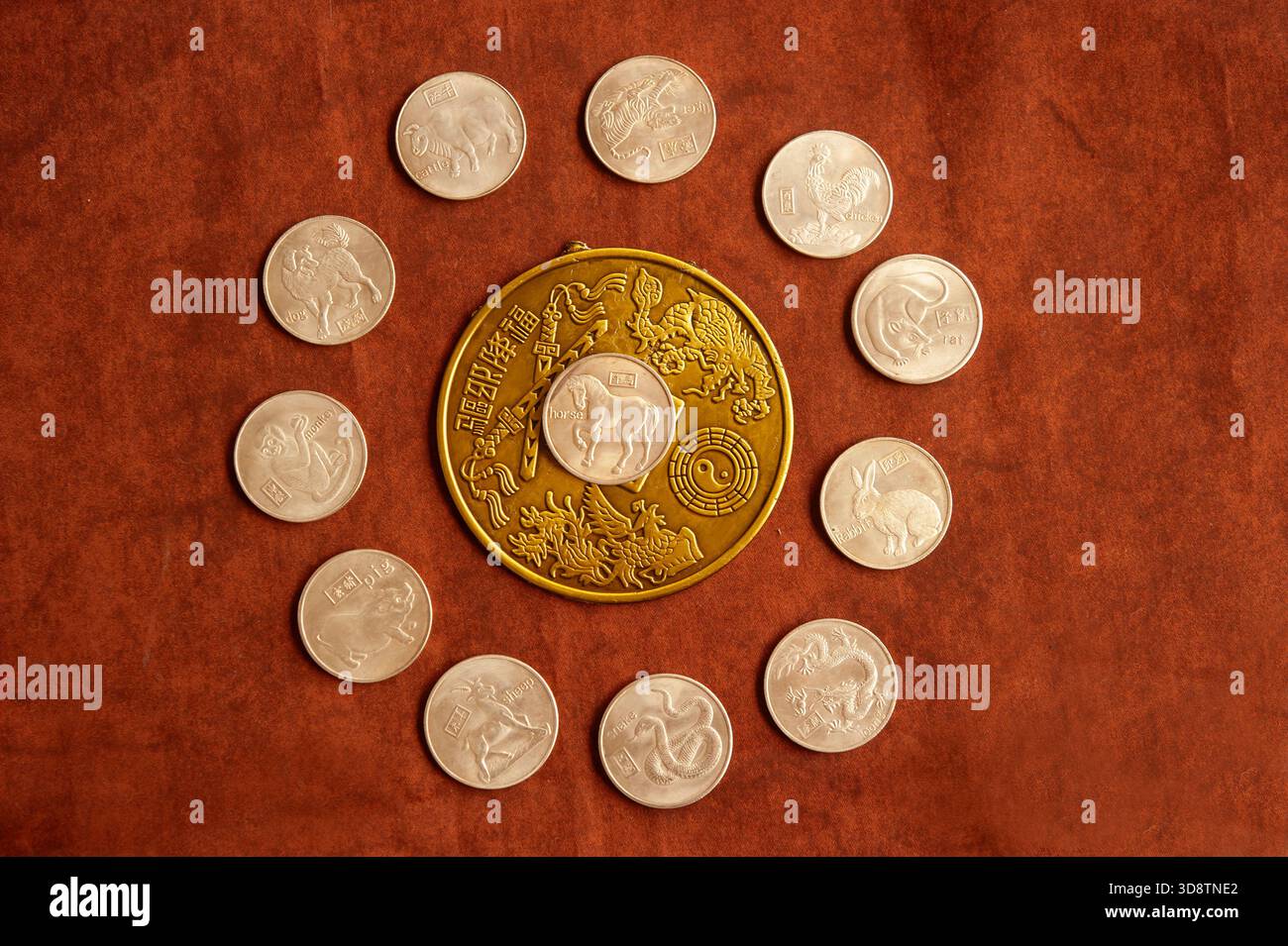 Moneta con il simbolo del cavallo di astrologia cinese circondata da altre monete zodiacali cinesi con simboli Foto Stock