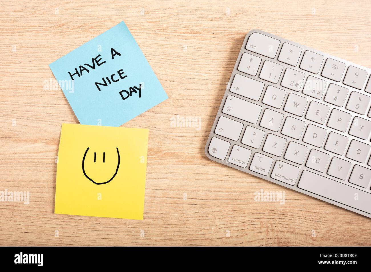 Nota motivazionale scritta a mano e sorridente su note adesive colorate nell'ambiente di lavoro moderno, produttività e tema di incoraggiamento. Foto Stock
