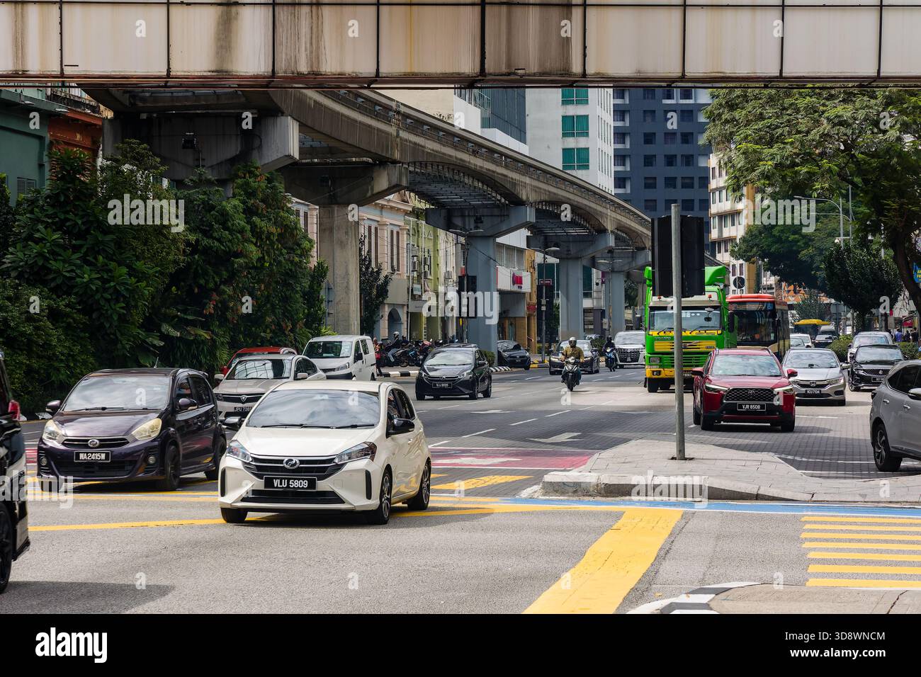 Vivace scena di strada con auto, moto e pista monorotaia a Kuala Lumpur Foto Stock