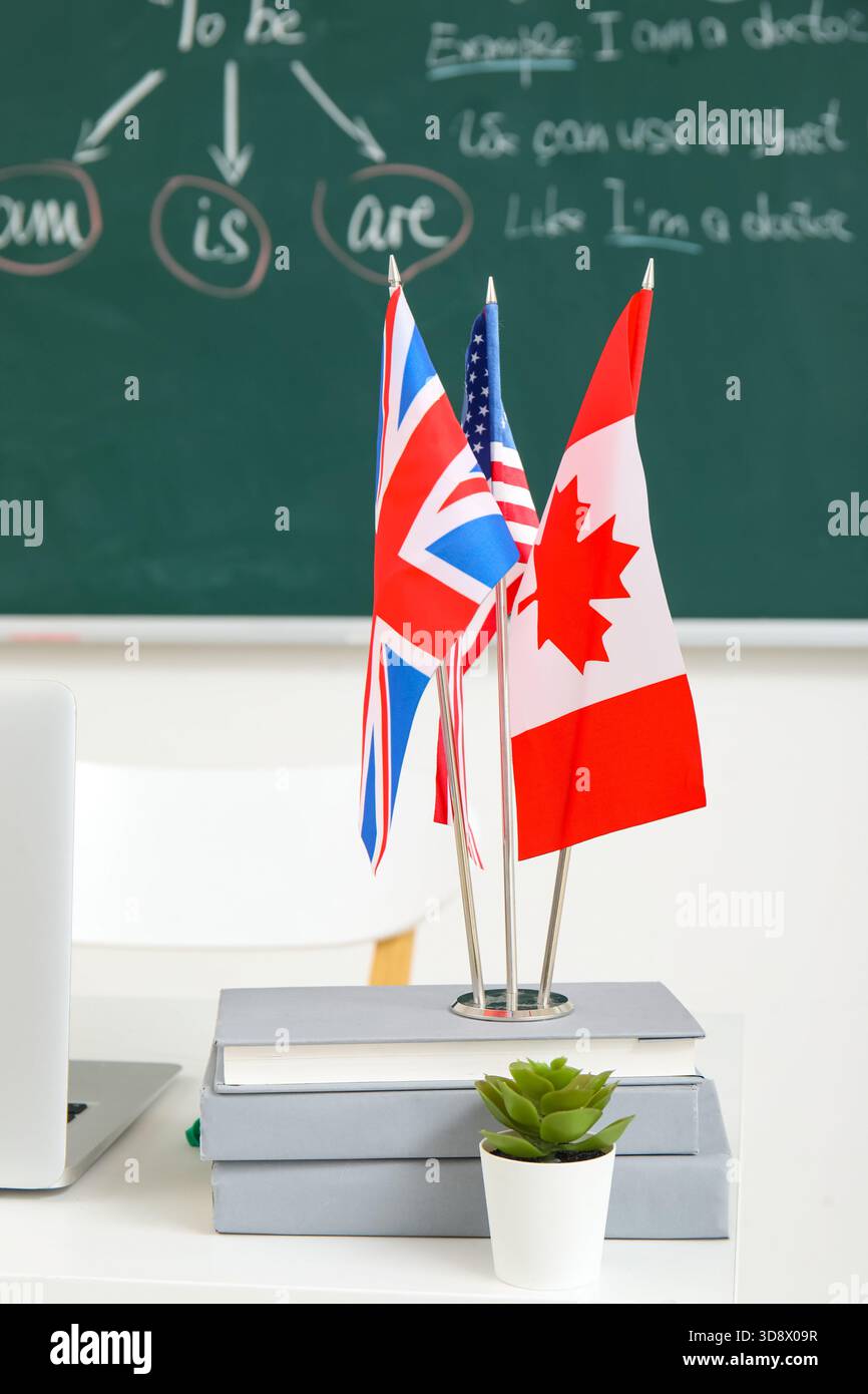 Bandiere diverse con libri sul tavolo in classe inglese Foto Stock