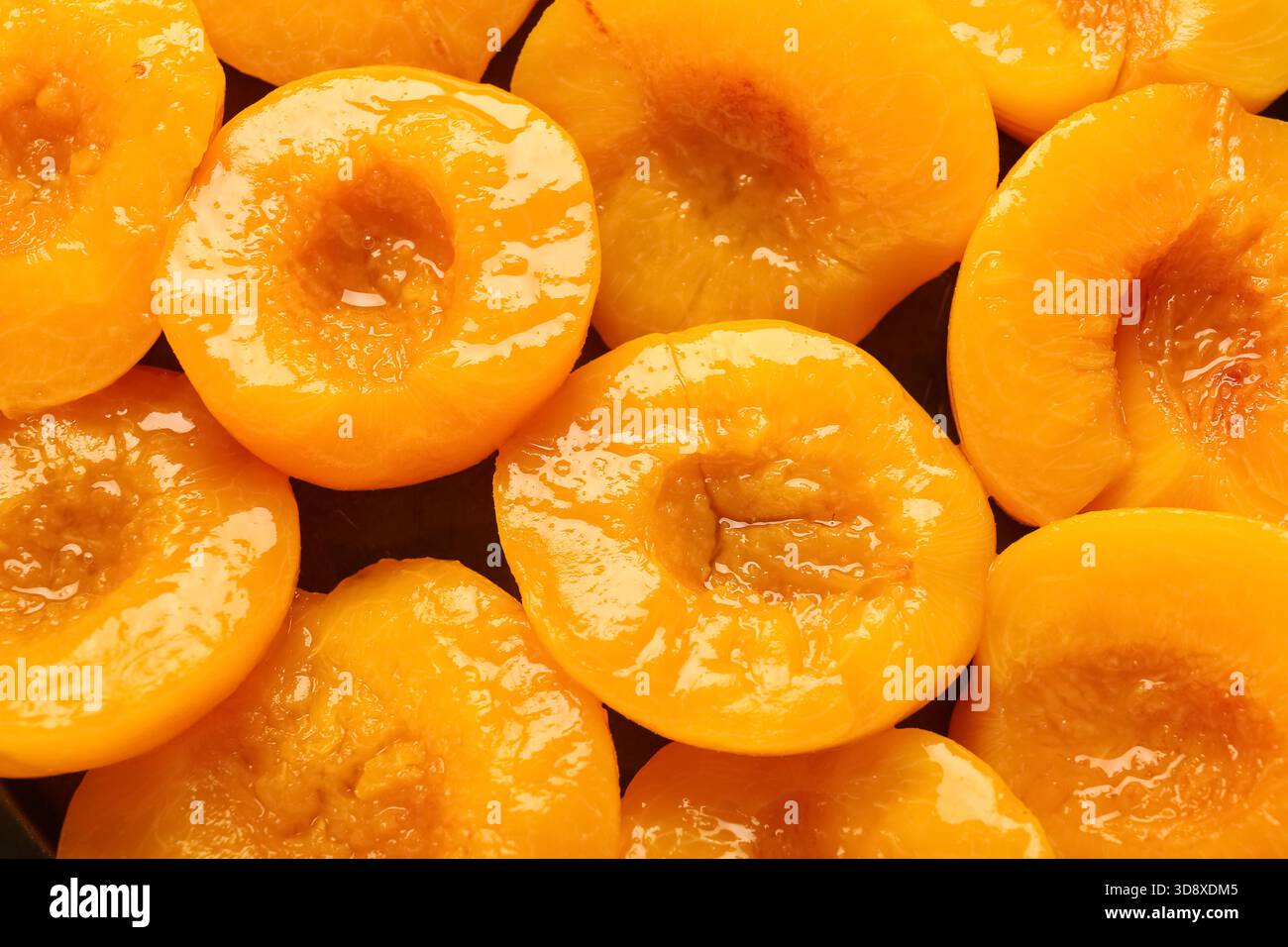 Consistenza di pesche dolci in scatola su sfondo scuro, primo piano Foto Stock