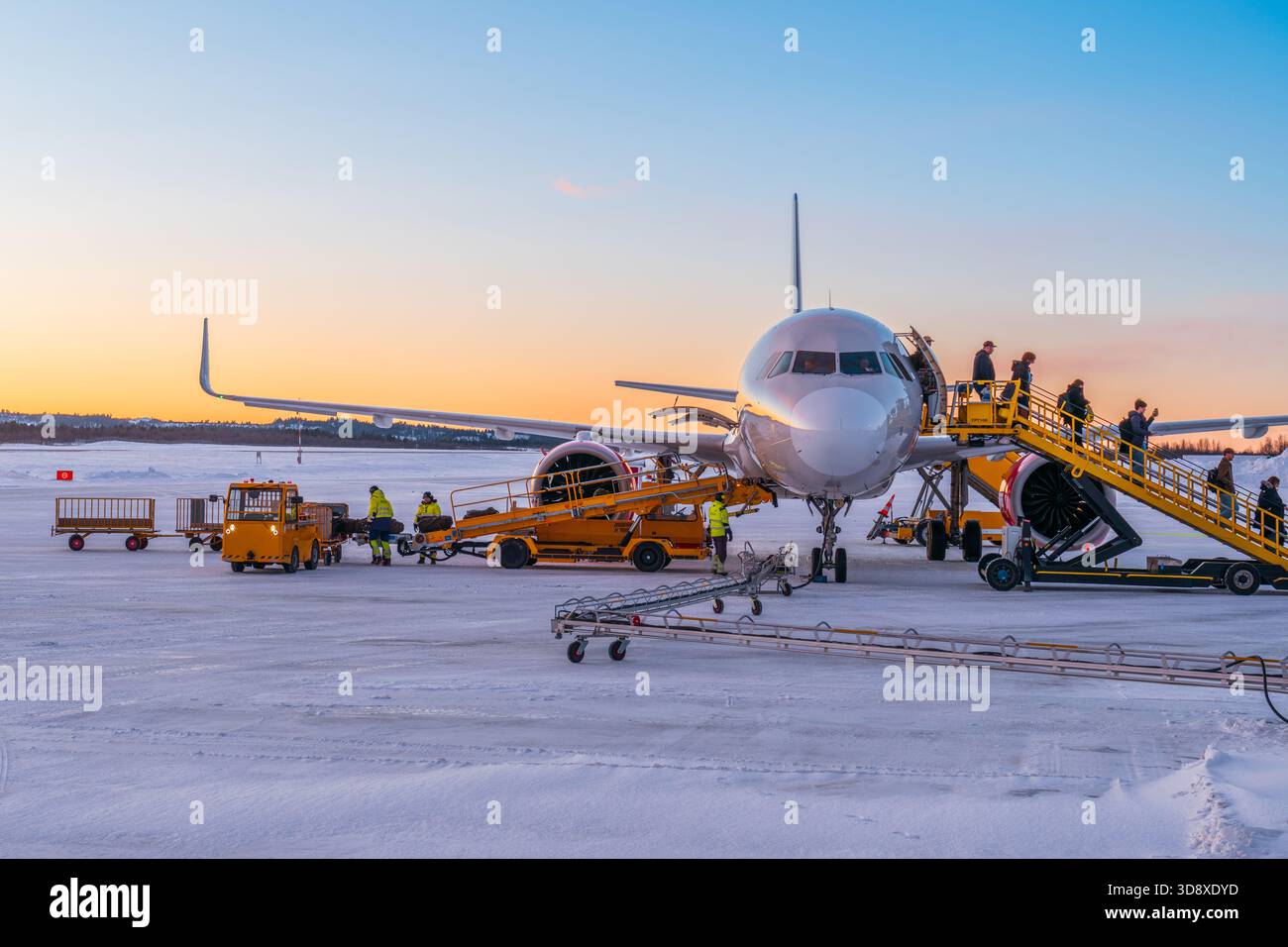 Persone che abbandonano un aereo nel nord artico della Svezia, all'aeroporto di Kiruna, durante la notte polare invernale Foto Stock