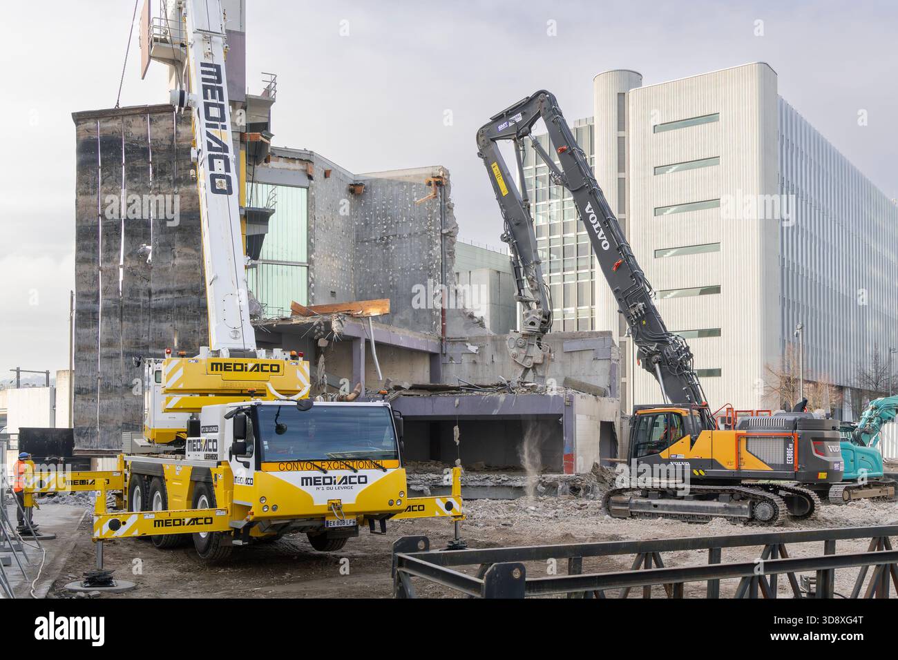 Nancy, Francia - Vista su un escavatore cingolato Volvo EC380E HR e una gru mobile Liebherr per la demolizione di un edificio in un cantiere. Foto Stock