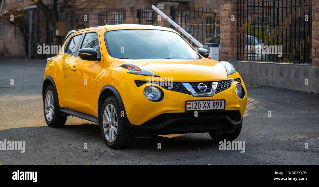 Erevan Armenia 11.25.2025. Un'auto Nissan gialla con targa MX-99 si trova in un parcheggio. L'auto è parcheggiata davanti a una recinzione Foto Stock