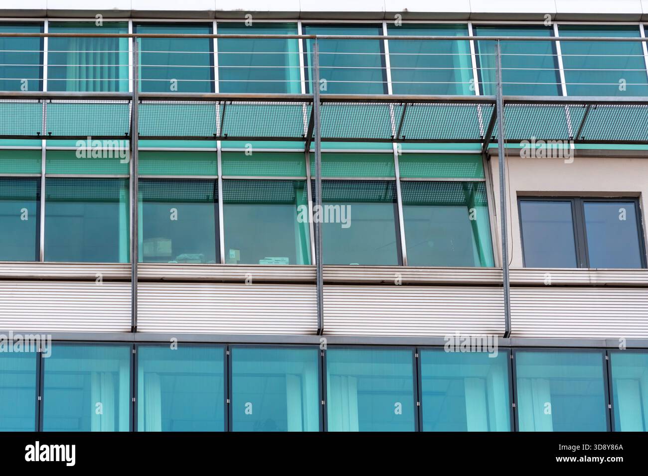Facciata in vetro di un edificio moderno con supporti verticali in metallo ed elementi strutturali esterni. Foto Stock