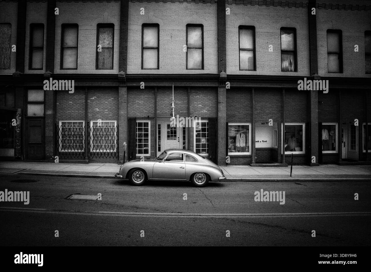 Porsche 365 d'epoca d'argento parcheggiata di fronte a un vecchio edificio in bianco e nero Foto Stock