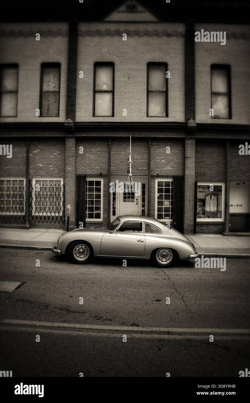 Porsche 365 d'epoca d'argento parcheggiata di fronte a un vecchio edificio in tonalità seppia Foto Stock