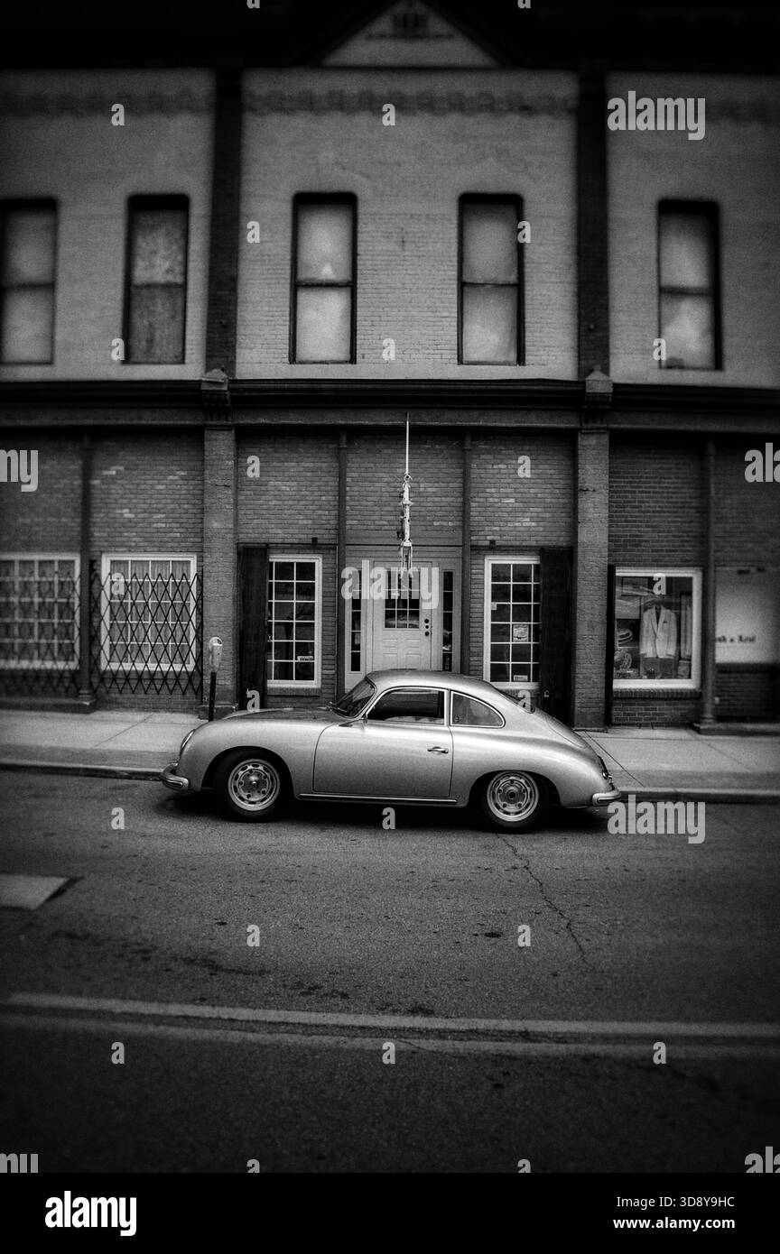 Porsche 365 d'epoca d'argento parcheggiata di fronte a un vecchio edificio in bianco e nero Foto Stock