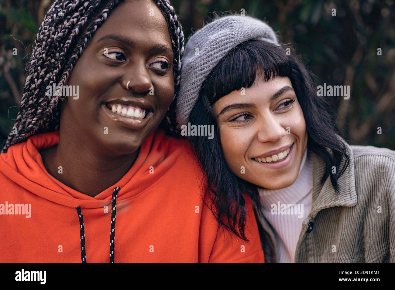 Primo piano ritratto di due felici donne multietniche che sorridono con la testa che toccano all'aperto in un parco. Foto Stock